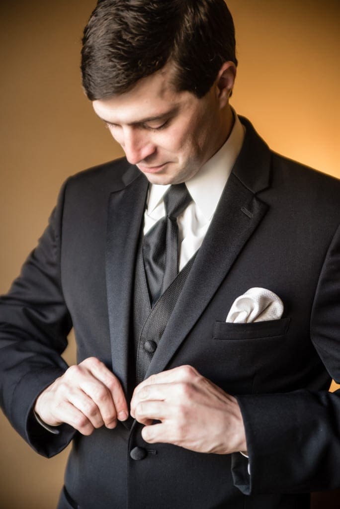 Chris buttoning his jacket, putting on the finishing touches.