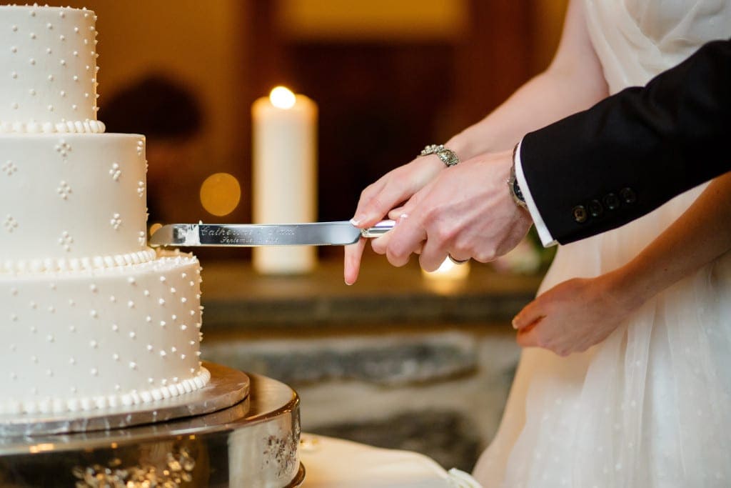 Cutting the cake with their engraved cake knife.