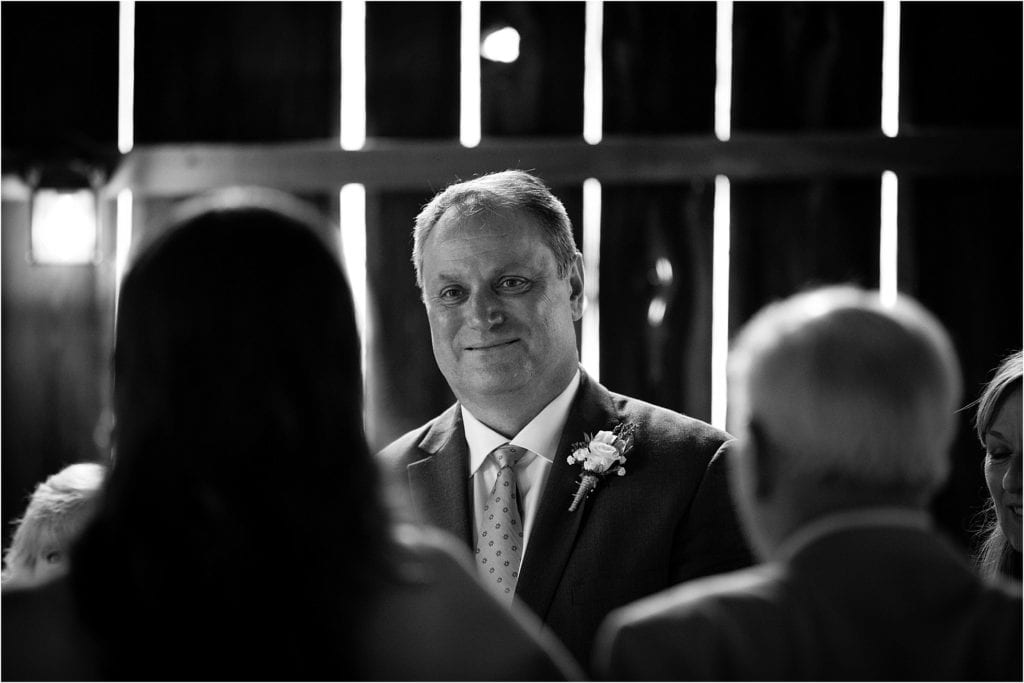 grooms reaction to bride walking down the isle yielded in this beautiful black and white photo- Rustic barn wedding