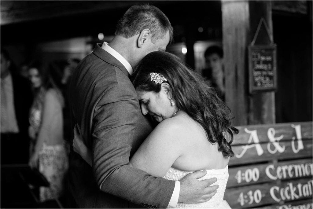 sweet moment during first dance at a rustic barn wedding 