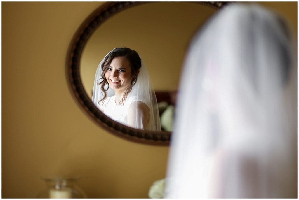 Photo of bride looking into Mirror
