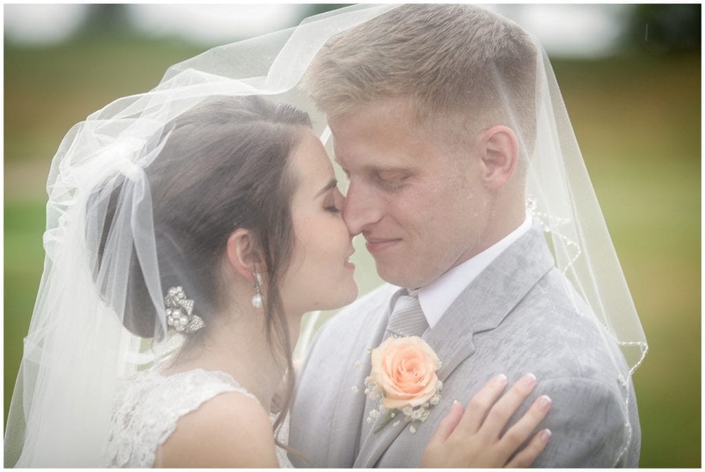 Romantic pose idea for pictures of bride and groom using veil 