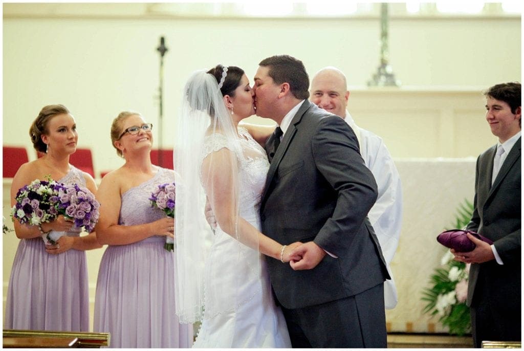 Bride and grooms first kiss at end of the wedding ceremony at Church of the Holy Trinity