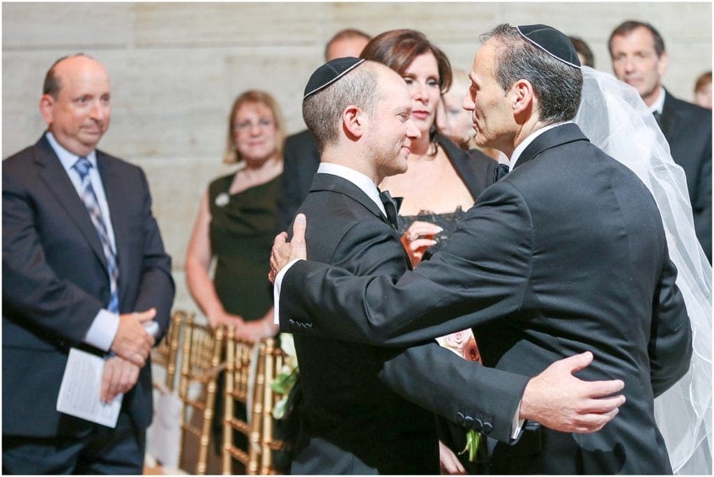 historical wedding venues in Philly- Groom hugging father of bride in ceremony 