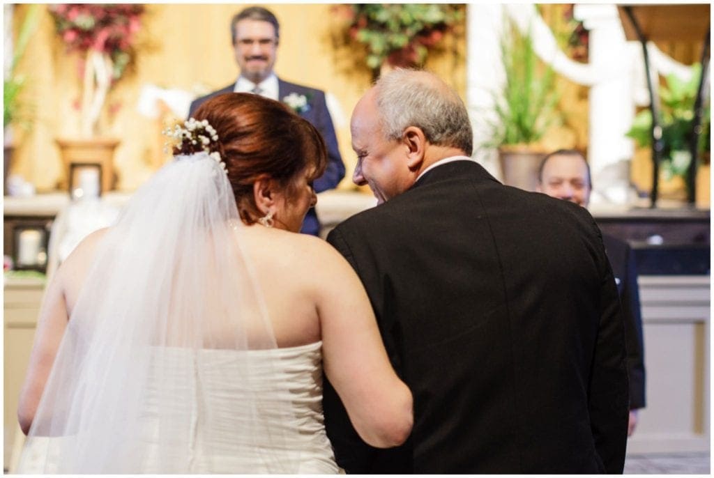 Bride walking down the aisle intimate moment with dad giving her away 