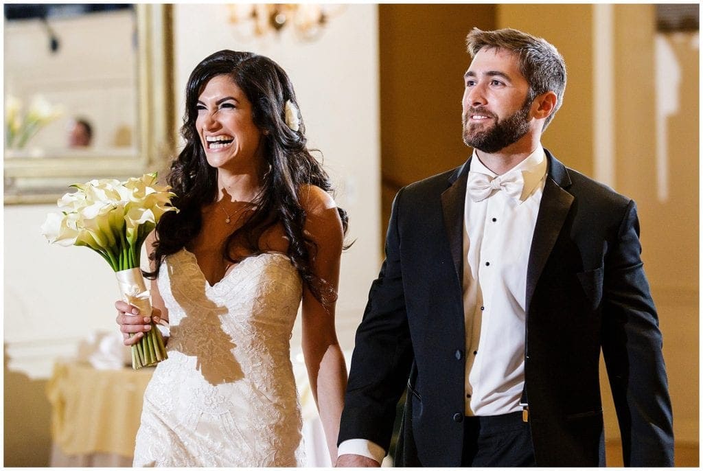 Bride and groom walking in their Huntingdon Valley Country Club wedding reception