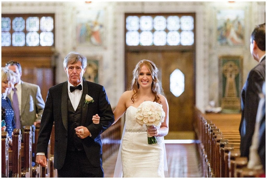 Emotional bride walking down the isle for her Irish Catholic wedding at St. Patrick's Church