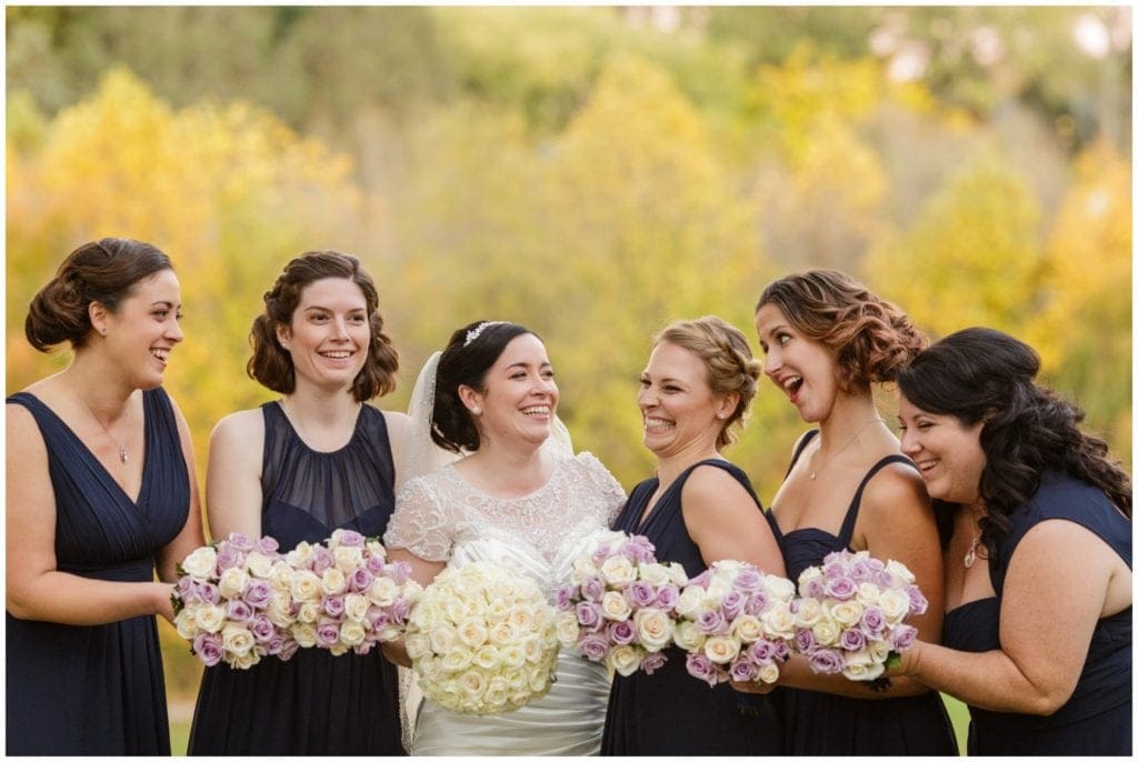 laughing bride and bridesmaids with purple and white bouquets- Fall wedding in PA 