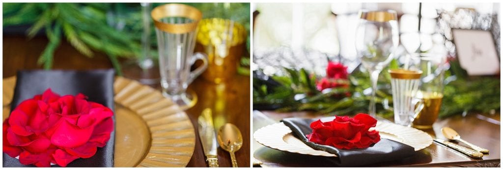 gold plates , black napkins and red flower 