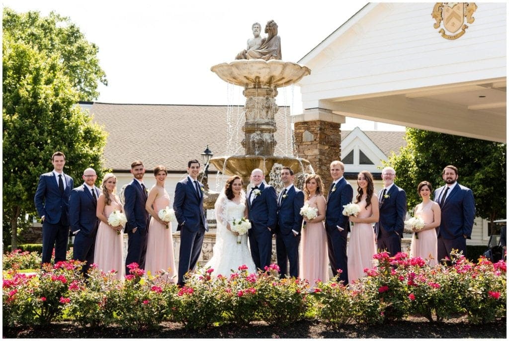 Bridal party in rose pink and navy blue in front of the fountain at Trump National Golf Club Philadelphia