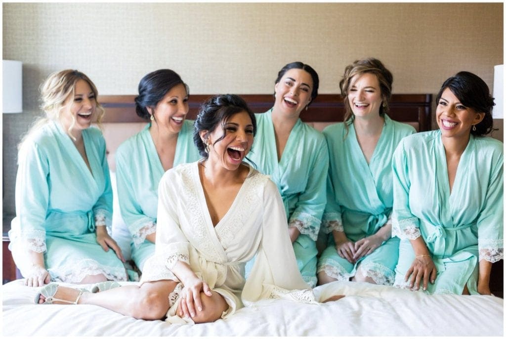 Bride with her bridesmaids in matching turquoise robes while the get ready for their Historic Penn Farm Wedding.