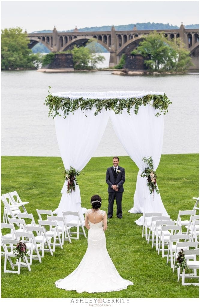 Outdoor wedding ceremony along Susquehanna River at John Wright Restaurant in Wrightsville, PA featuring design by Shumaker PDT