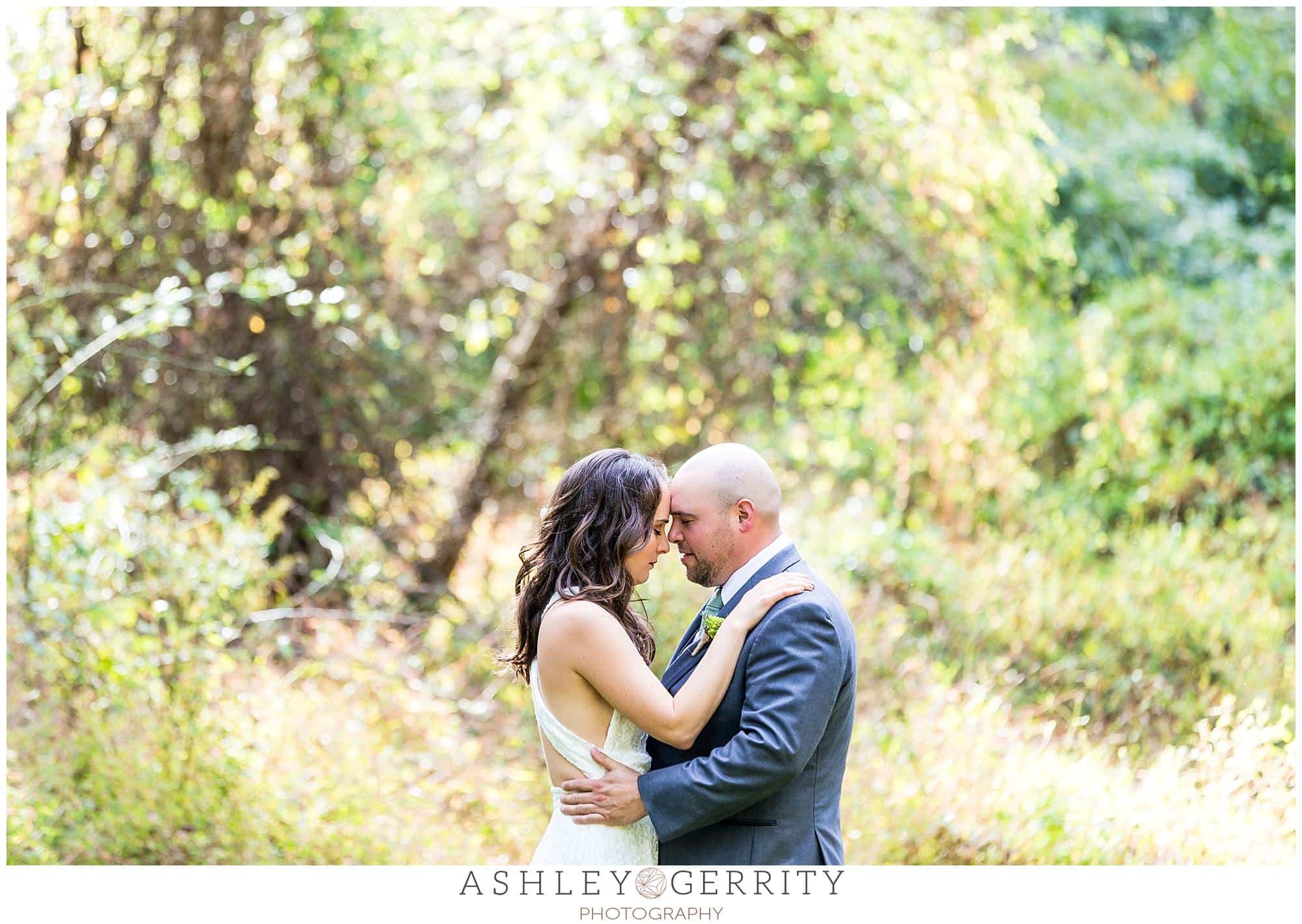 Bride & groom happily embracing in a field during their Chester Springs wedding 