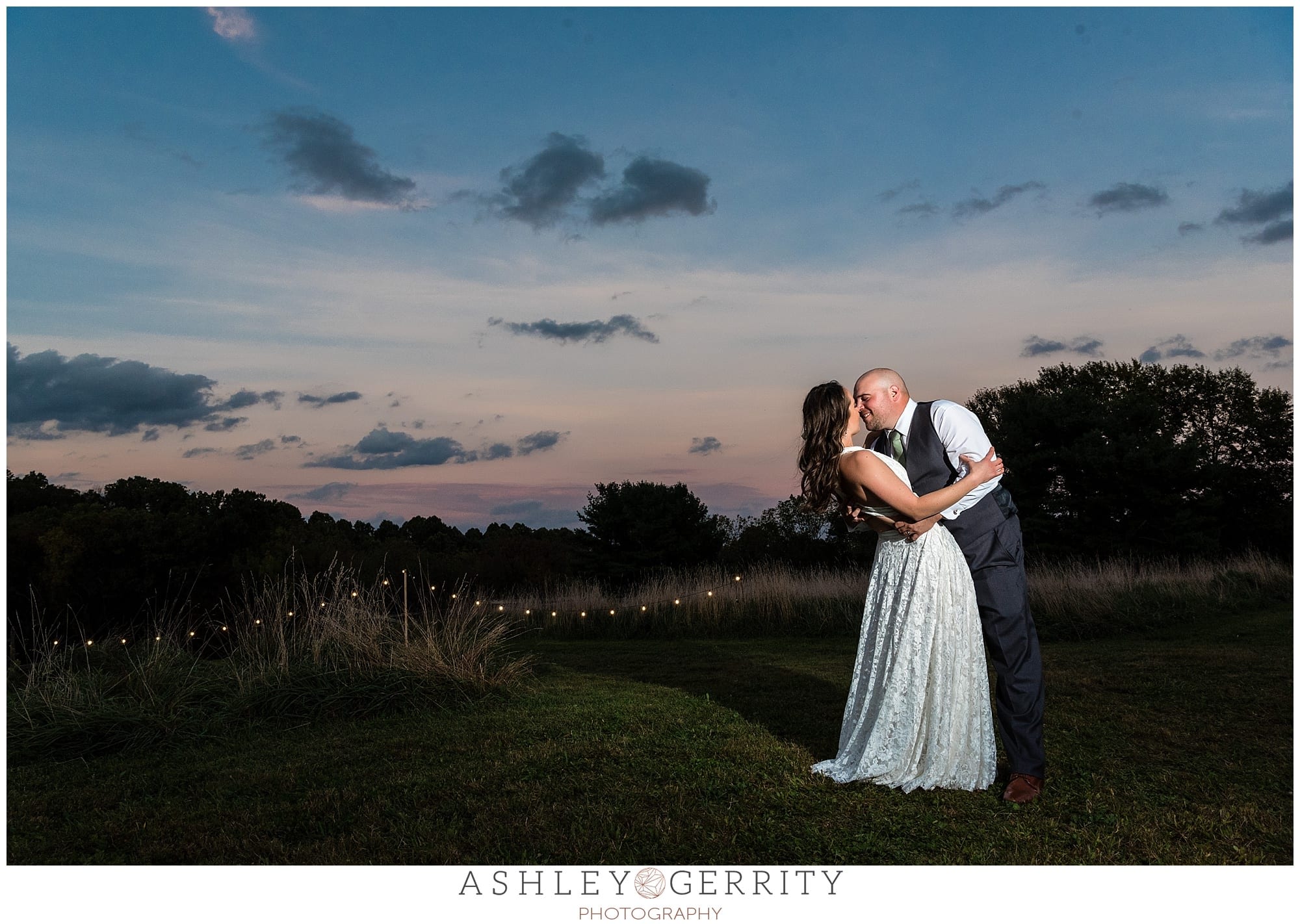 Sunset portrait of groom dipping bride with a sweeping rustic view.
