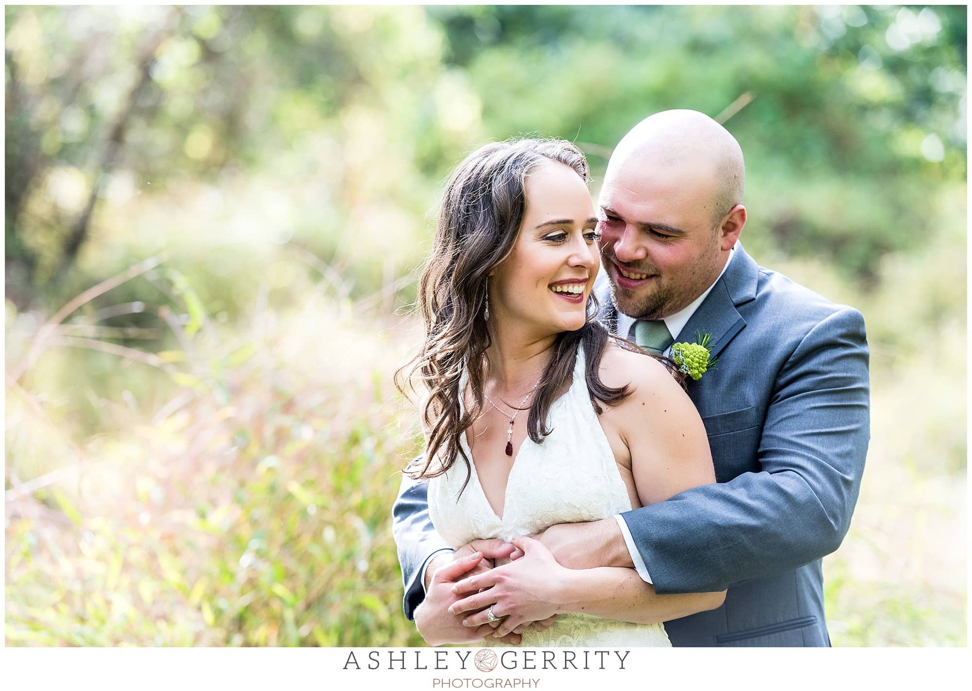 Bride & groom happily embracing in a field during their Chester Springs wedding 