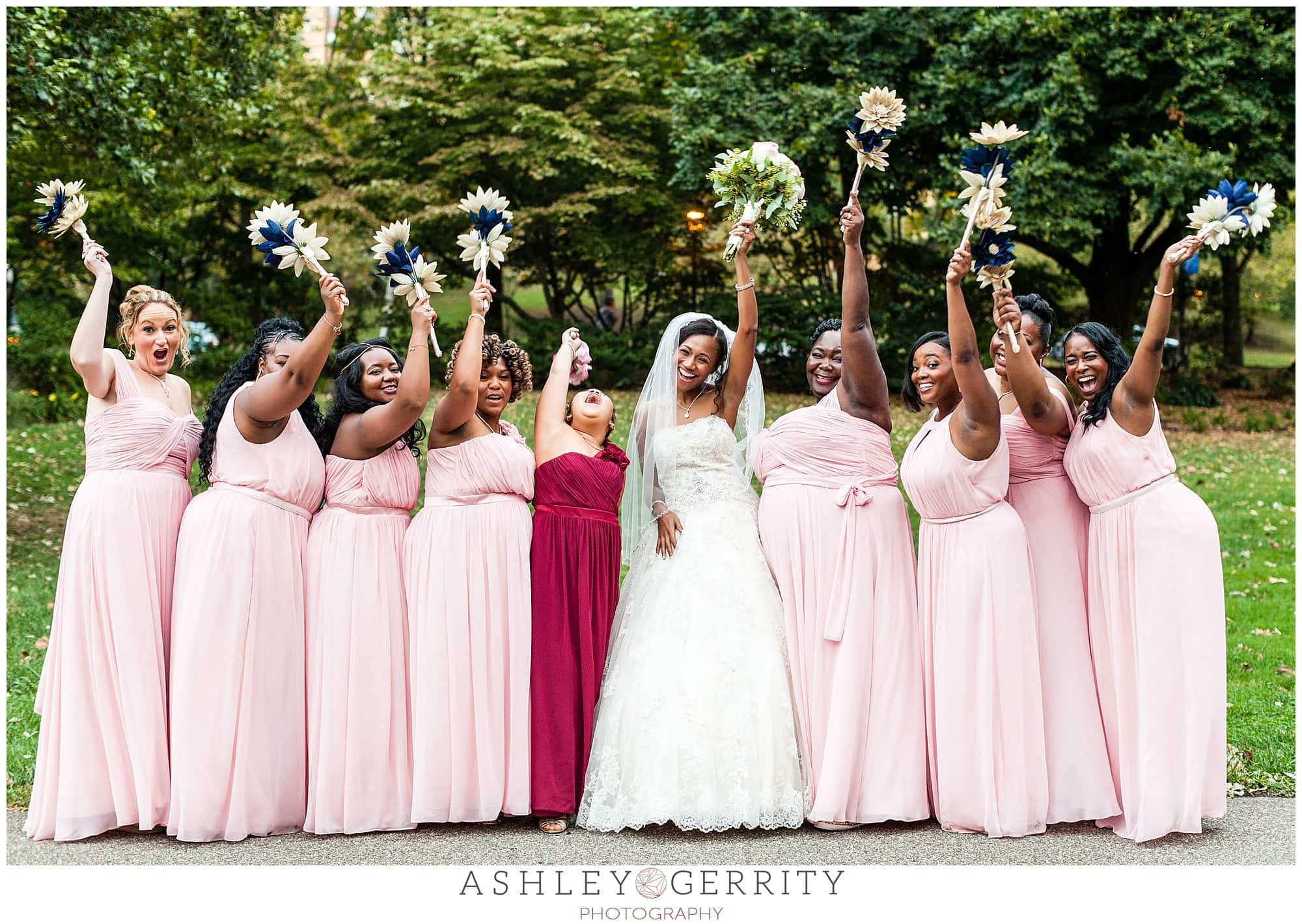 Bride & her wedding party lift their wedding bouquets in the air in celebration at the Philadelphia Museum of Art Azalea Garden