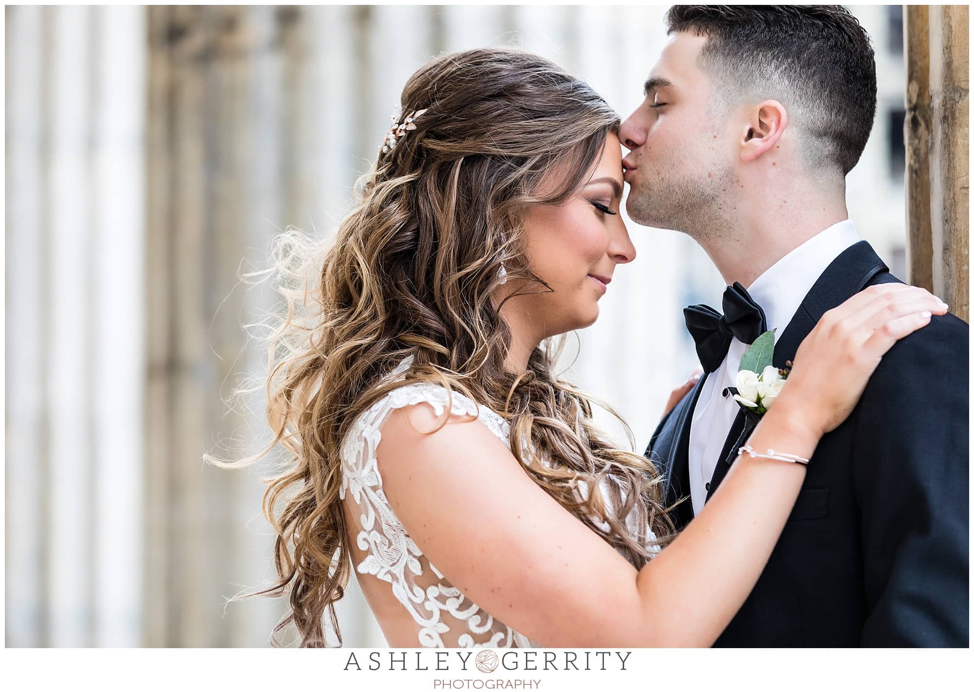 wedding portrait groom kissing brides forehead 