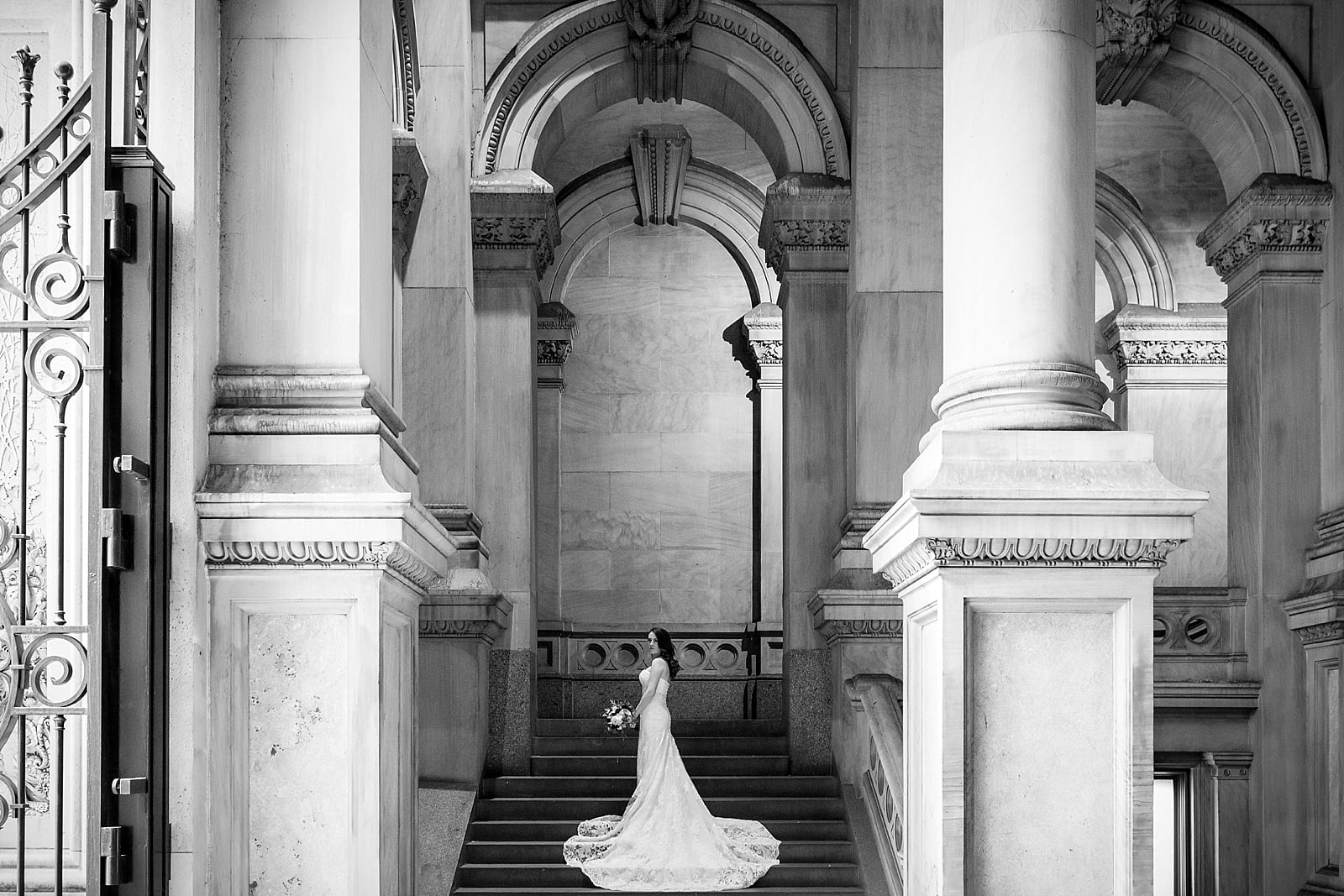 Black and white bridal portrait from behind with long gown train in grand stairway, college of physicians wedding