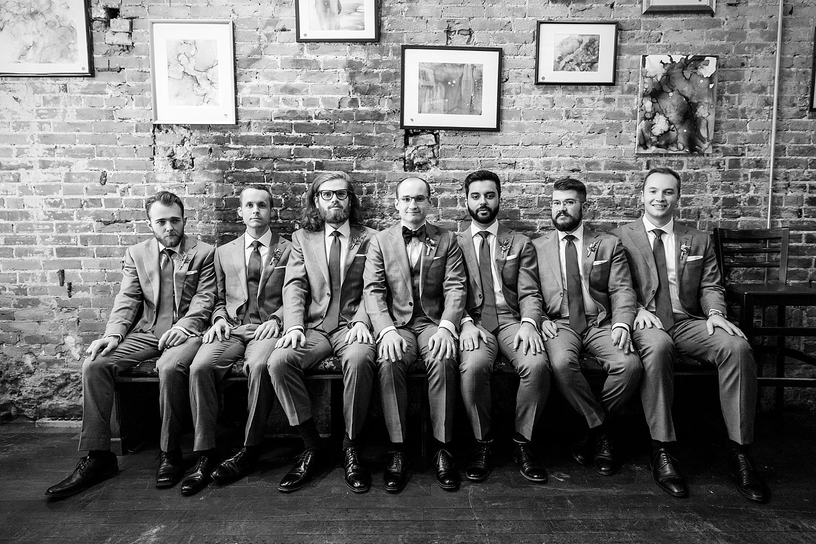 Black and white groomsmen portrait sitting on bench, college of physicians wedding