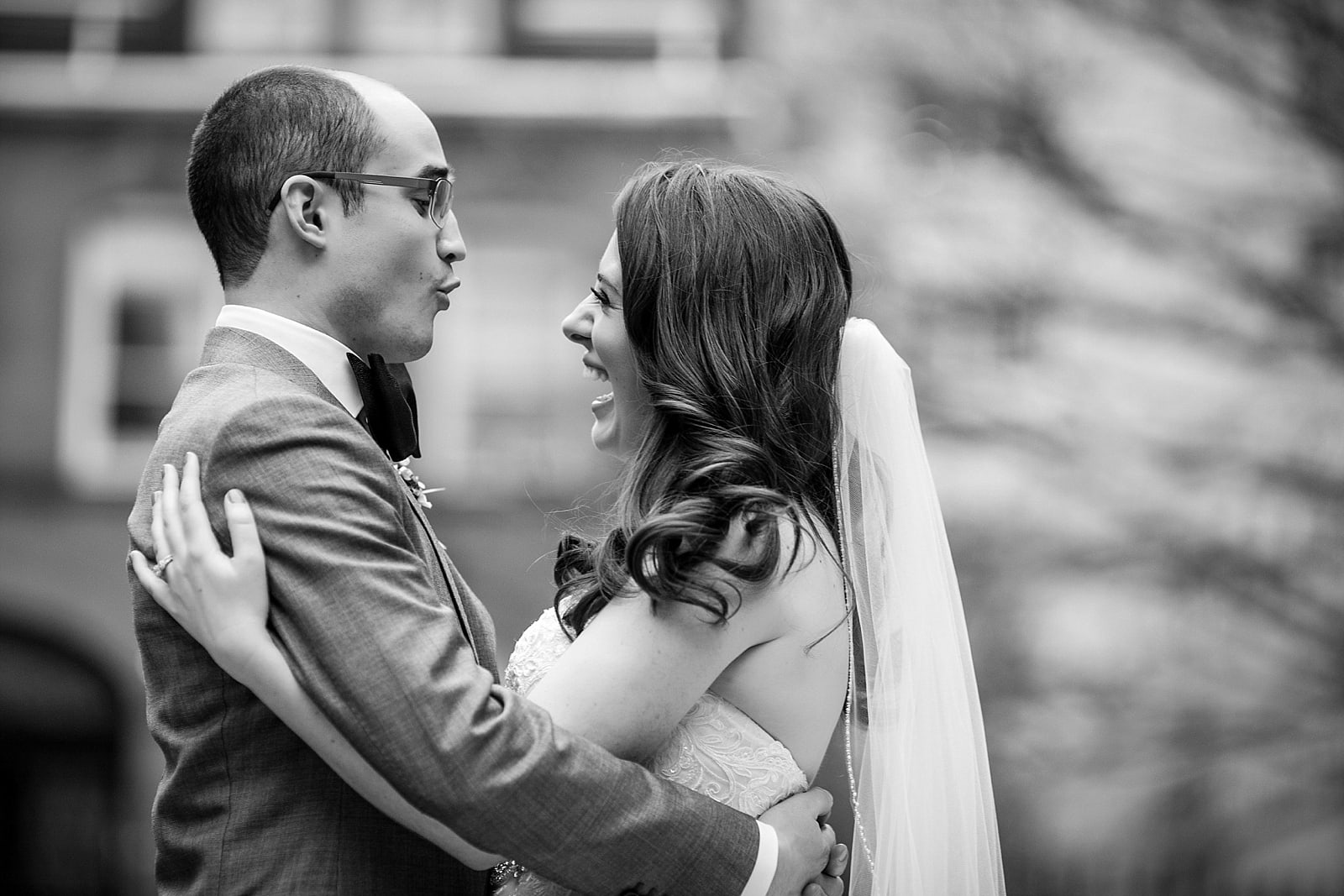 Black and white bride and groom portrait, bride and groom hugging and laughing