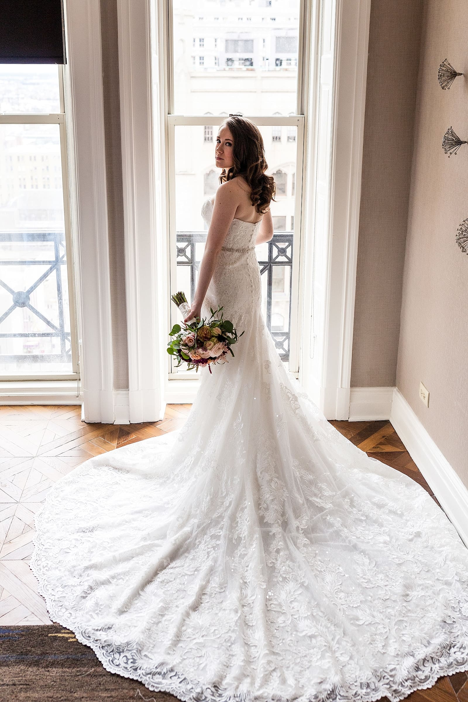 Bridal portrait from behind with bouquet, long wedding dress train and bridal bouquet 