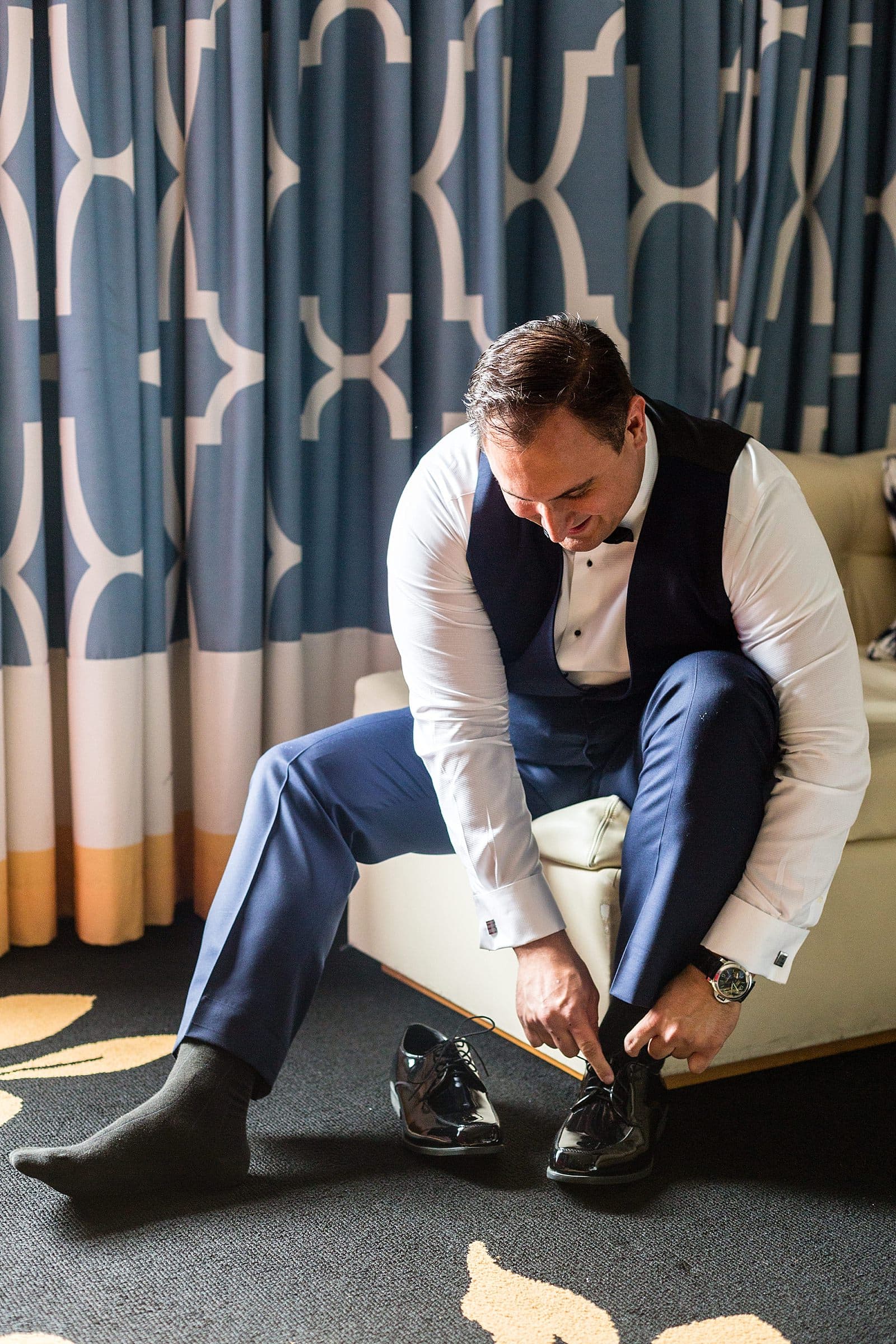 Groom ties his shoes, Kimpton Hotel Monaco Philadelphia