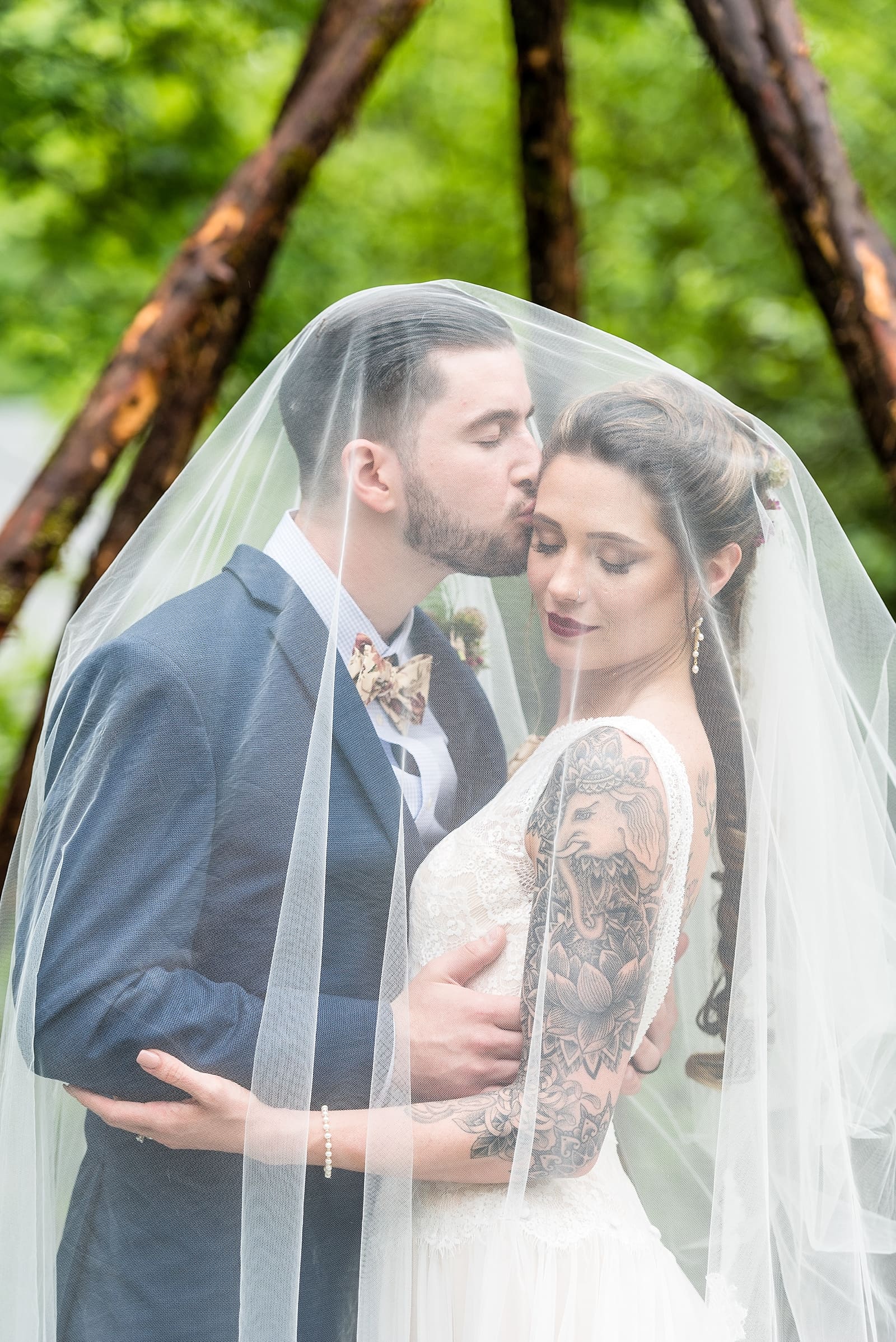 wedding portraits of tattooed bride and groom under the veil at the Inn at Millrace Pond
