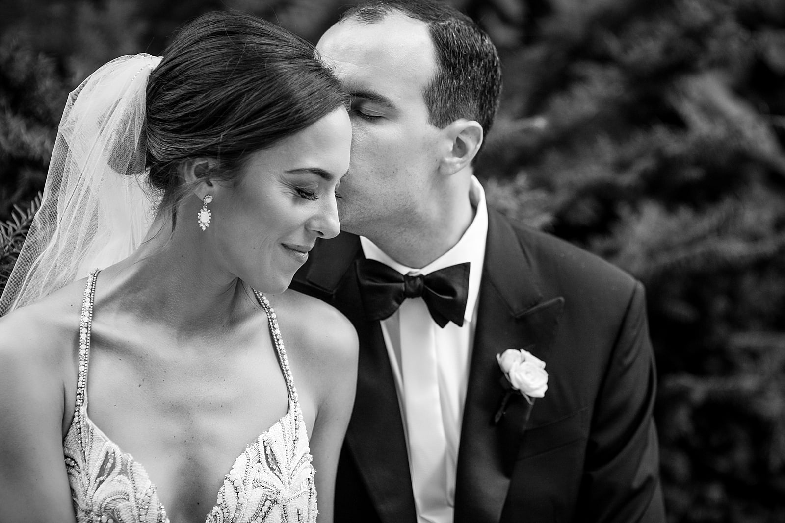 Bride and groom portrait, groom kissing bride on the cheek, black and white wedding portrait