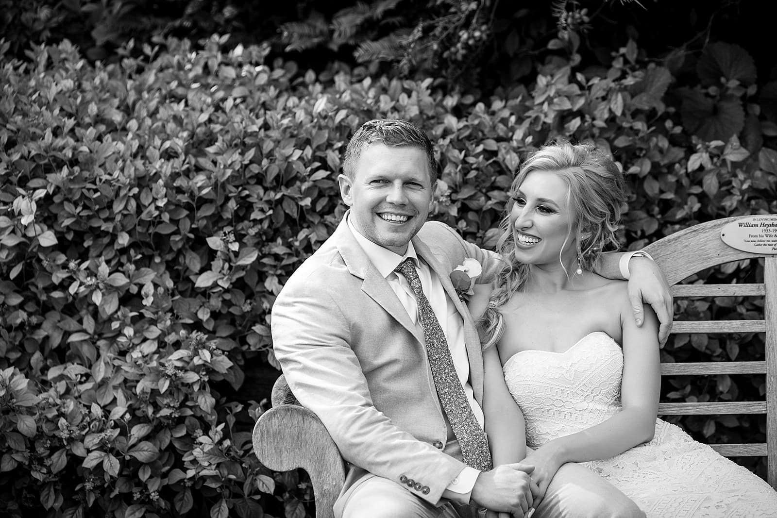 black and white wedding portrait, bride and groom sitting on bench, husband and wife