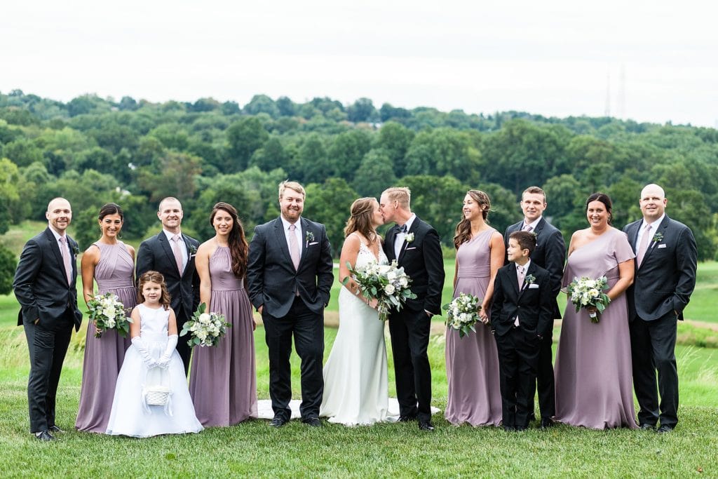 Bride & groom kiss with their wedding party