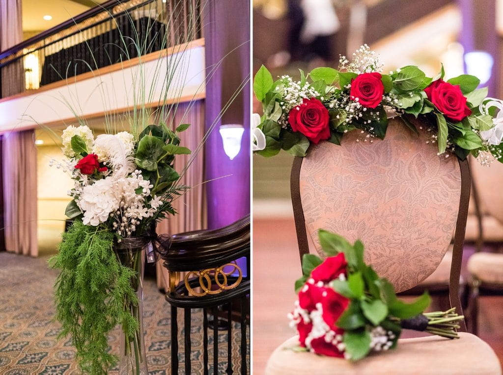 Hanging evergreen with red roses and pearls on the staircase of the Collingswood Ballroom. Special chair designated in memory of the bride's mother decorated with a bouquet and garland of roses.