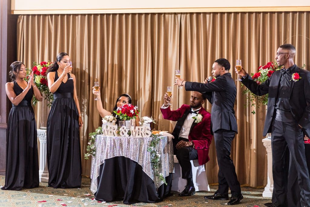 Wedding party raises a glass during a groomsman's toast