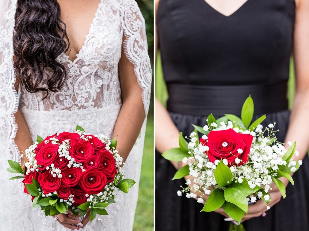 Red rose bouquets against a bride's long sleeved lace Galina Signature wedding dress and a black satin bridesmaid dress