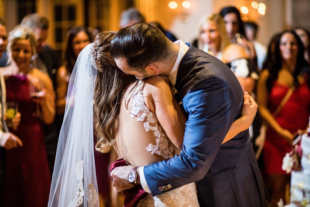 Groom embraces his bride at the end of their first dance