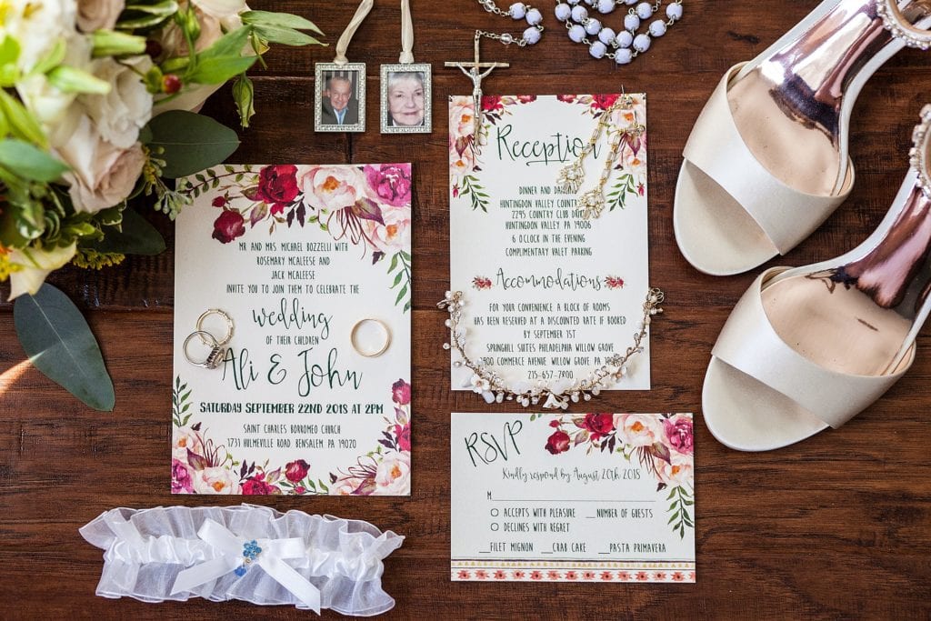 Flat lay of colorful floral wedding inspiration with garter, personal jewelry, and shoes