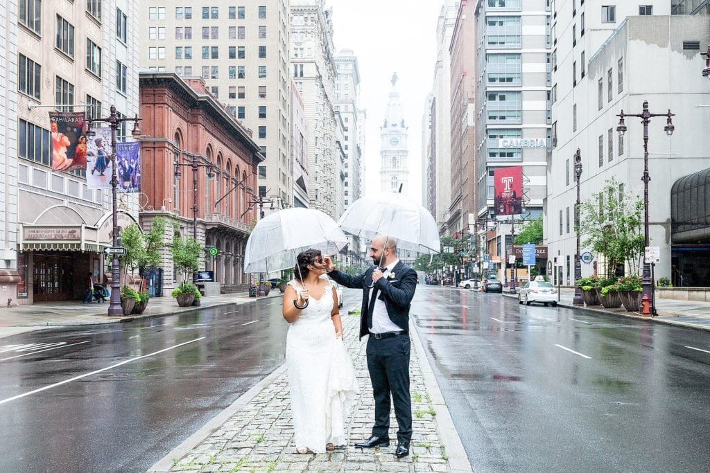 groom fixing brides hair, broad st, iconic philadelphia wedding pictures