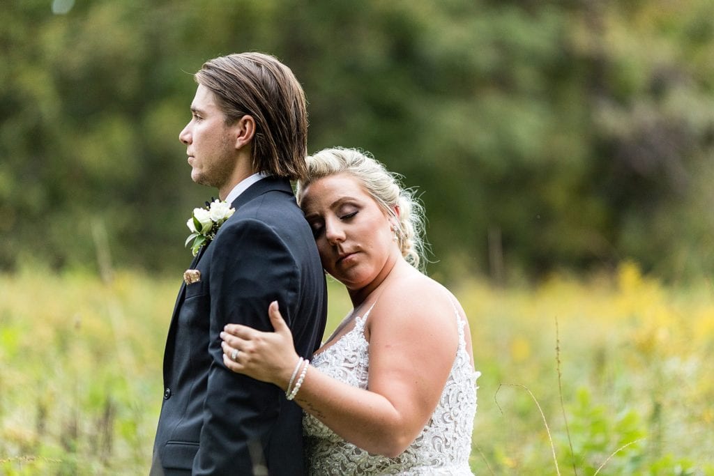 Bride leaning against her groom for a wedding photo at John James Audubon Center
