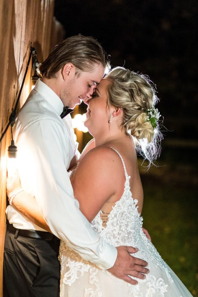 Groom and bride embrace for wedding photo inspiration at the end of their John James Audubon Center wedding reception