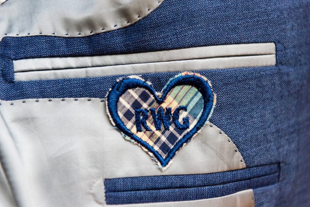 Grooms initials embroidered inside of his blue suit on a heart