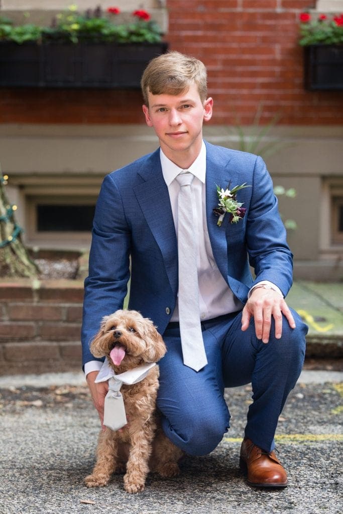 Groom takes a knee next to his best dog, wearing matching bow ties