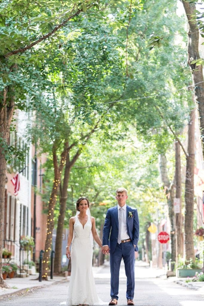 Bride & Groom hold hands for a wedding photo on Addison St in Philadelphia before their Kimmel Center Wedding