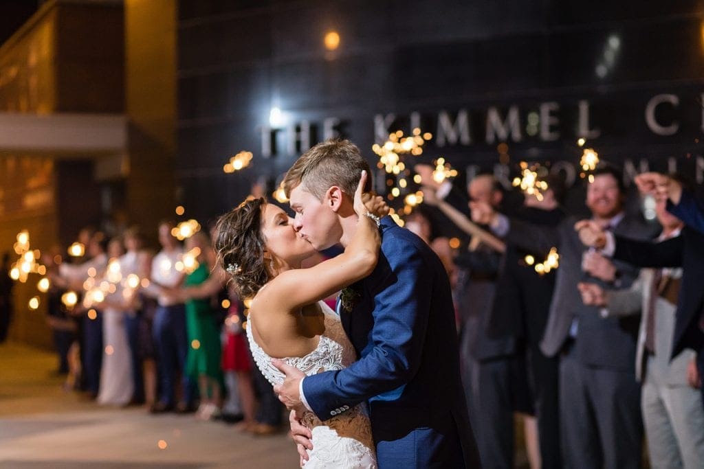 Bride & groom kiss during a sparkler exit along Broad St in front of their Kimmel Center Wedding