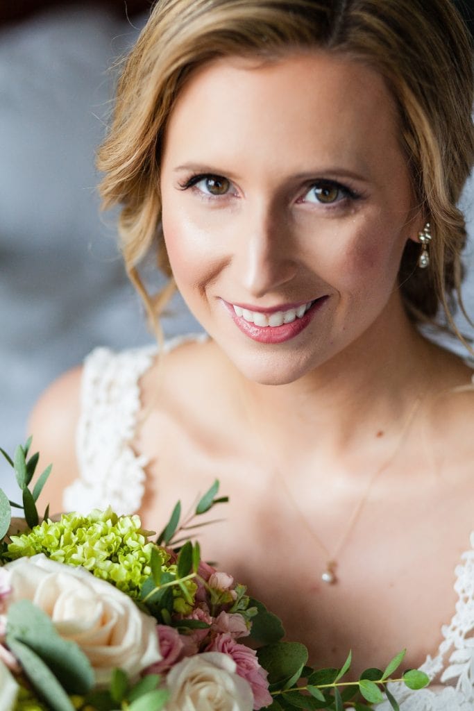 Window lit wedding portrait of a smiling bride