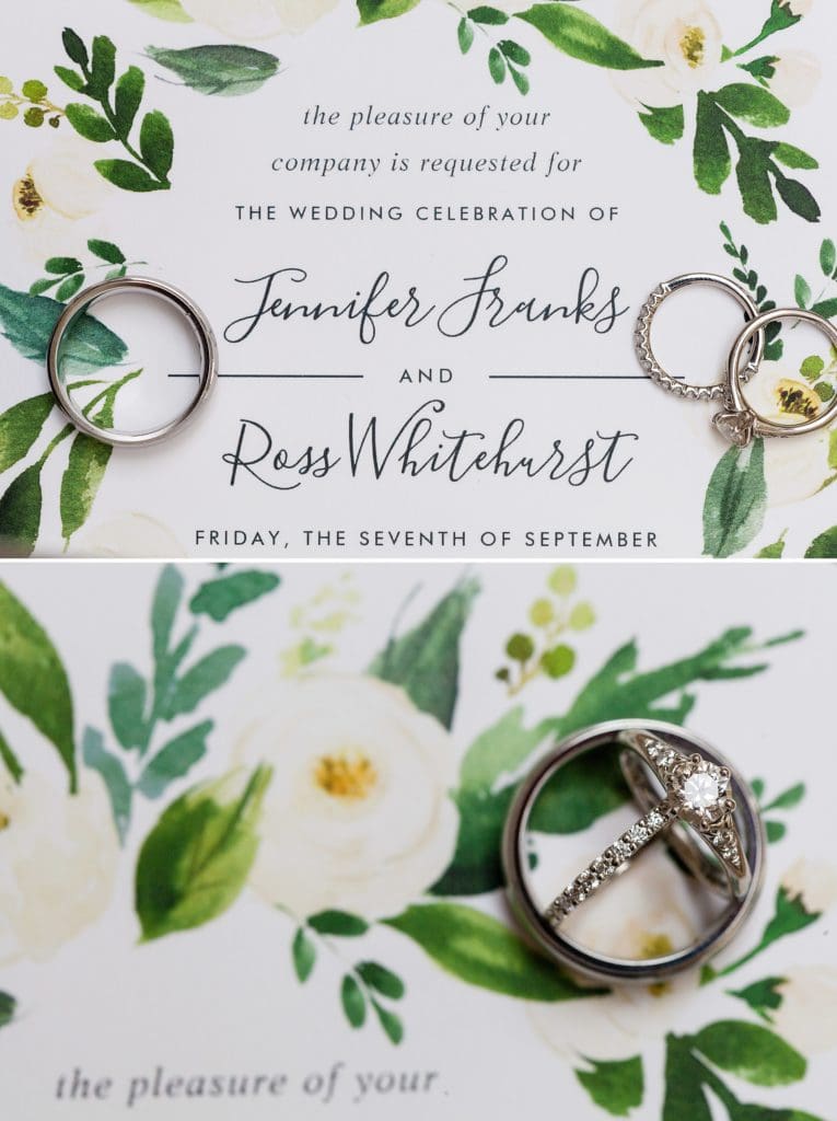 Wedding rings against a greenery inspired wedding invitation
