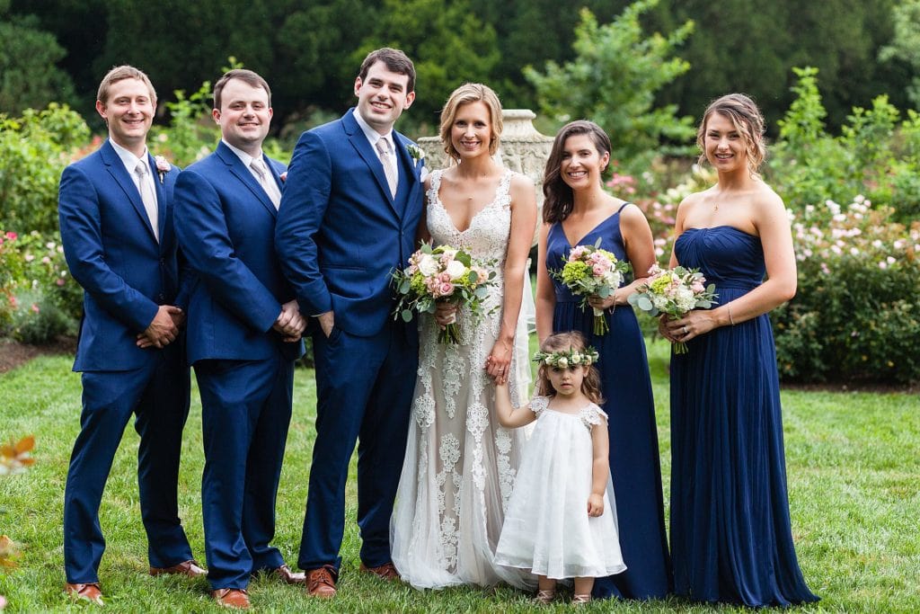 Portraits of a wedding party dressed in royal blue in the rose gardens of Morris Arboretum