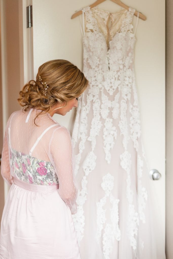 Bride prepares to put on her lace wedding dress