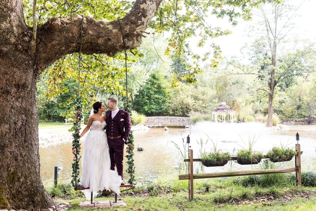 bride & groom portrait on a floral swing