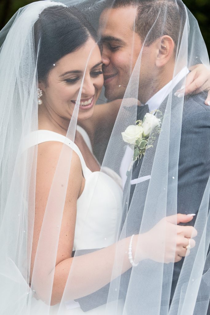Bride & groom smiling under the veil