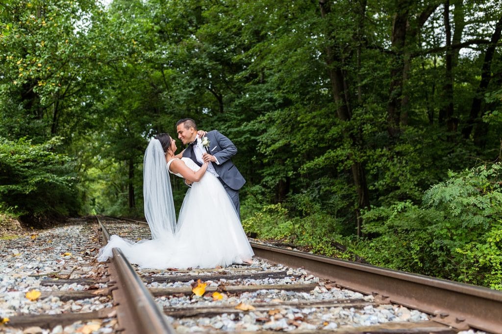 Groom dips his bride on the abandoned railway tracks behind the Mendenhall Inn
