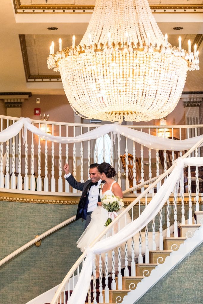 Bride & groom enter their reception down the grand staircase at the Mendenhall Inn